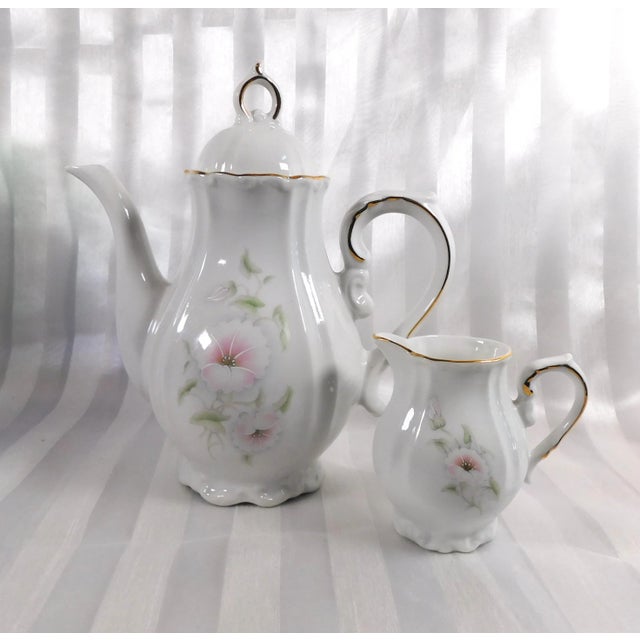 This is a smaller white shaped tea pot or coffee pot marked the Winrose Collection and Hand Decorated in USA. I don’t know...