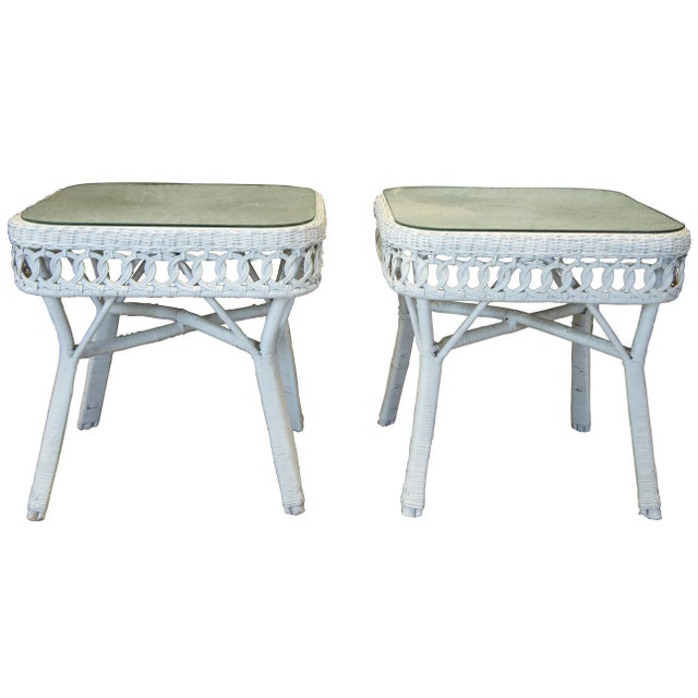 Pair of two vintage white wicker, rattan and bamboo side tables featuring glass tops and interlocking rattan loop design.