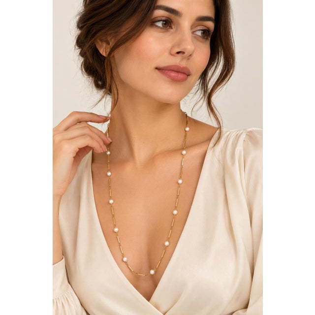 A graceful and contemporary play on classic opera-length pearls, this long station necklace is crafted in solid 14K and...