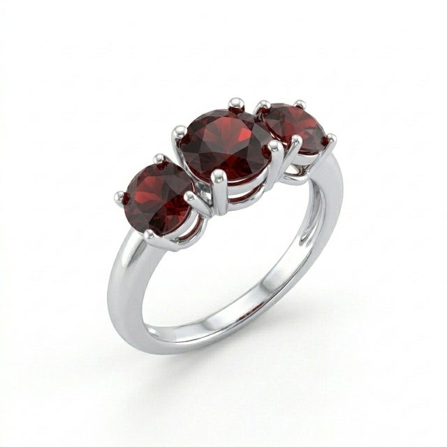 This striking ring features three round-cut garnet gemstones, each radiating a deep, rich red hue that embodies passion,...