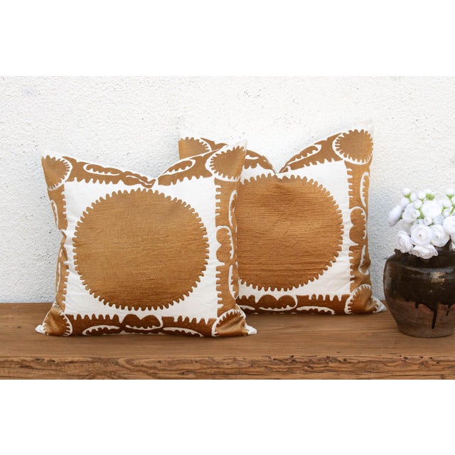Sold as a matching pair, these pillows feature a large sun-disc medallion hand-embroidered in gold-tan thread, framed by a...