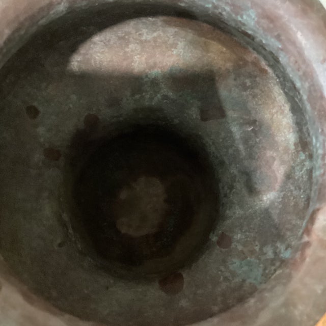 The product described is a large, brown, antique Victorian style hand-hammered copper garden urn with original patina....