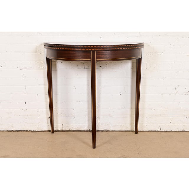 A gorgeous Federal or Hepplewhite style flip top demilune console game table In the manner of Baker Furniture USA, Circa...