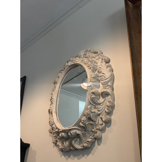 An exquisite reproduction in caste resin Italian Rococo- style mirror featuring flowing acanthus leaves, grape clusters,...