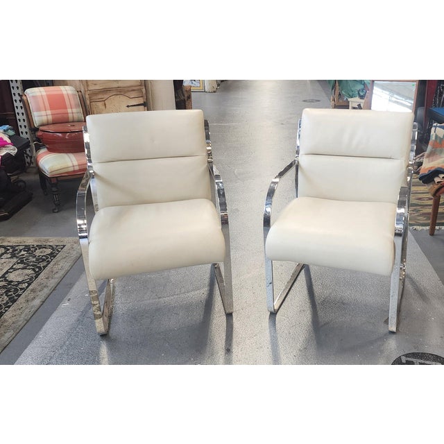 This is a very fine pair of stainless steel framed with leather seats dining room chairs designed by Charles Gibilterra...