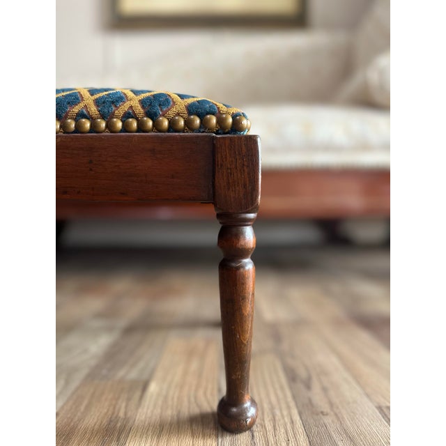 Charming antique mahogany footstool with a clean rectangular form, turned legs, and a newly upholstered top in a rich blue...