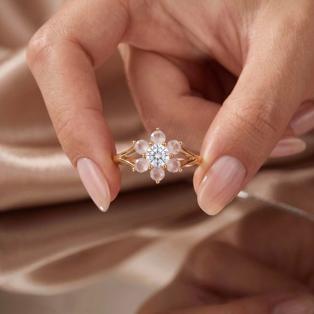 Exuding soft, romantic charm, this botanical ring showcases a blooming halo of delicate blush-pink gemstones surrounding a...