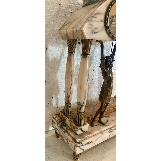 Empire style mantel clock set, inspired by the egyptian revival marble column clock with chased bronze ring two female...