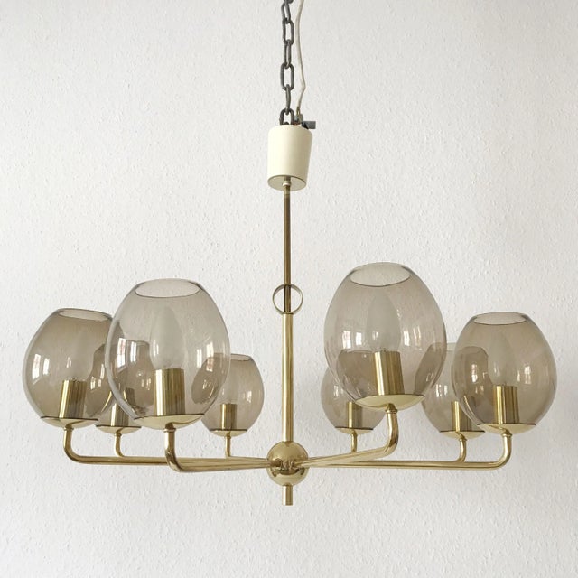This eight-armed ceiling light was produced in Germany between the 1950s and 1960s. The lamp has its original wiring and...