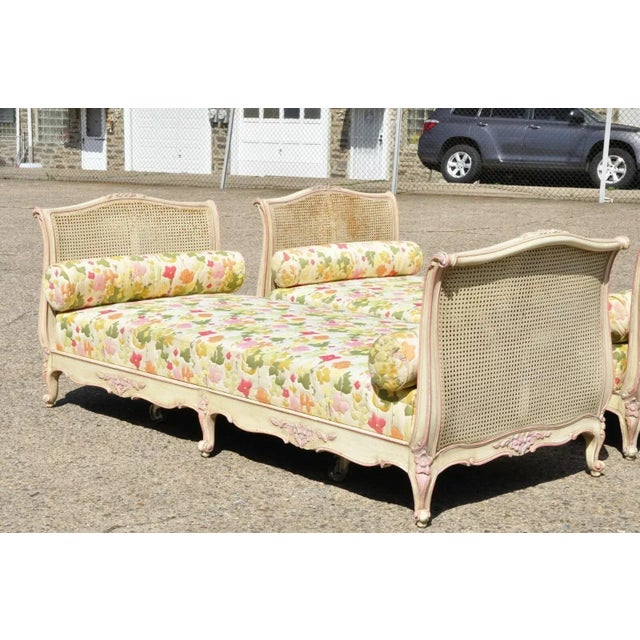 Pair of Antique French Louis XV Style Pink & Cream Painted Carved Wood & Cane Daybeds. Item features double cane foot and...
