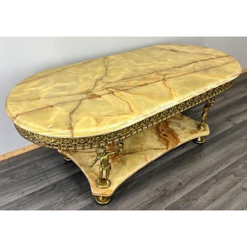 This elegant Vintage French onyx coffee table is a striking decorative piece, featuring a beautifully veined onyx top...