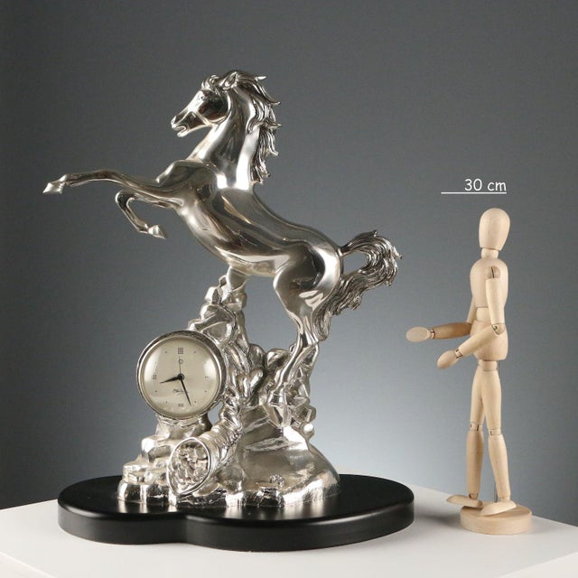 Clock set in a silver-plated resin sculpture depicting a prancing horse. Manufacturer's mark engraved on the base....