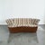 A sleek modern sofa in the style of Weiman for Preview. This piece features a curved design with a thick brown wrap-around...