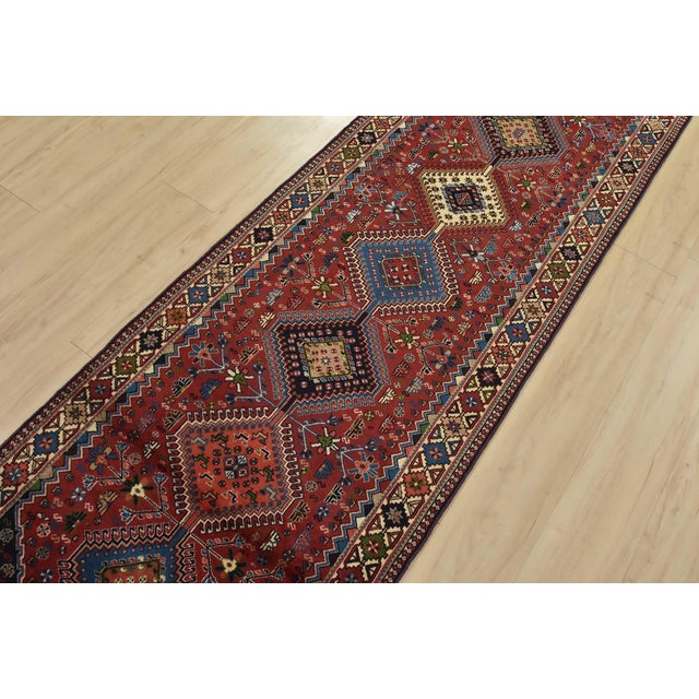 An authentic vintage tribal Yalameh runner hand-knotted with fine wool and natural dyes. This intricately woven rug...