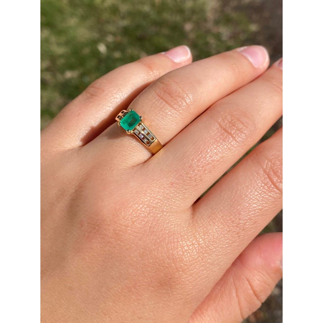 The Montro: Emerald Cut Natural Emerald and Diamond Ring in Yellow Gold. This ring showcases a captivating emerald-cut...