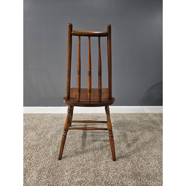 This mid-to-late 20th-century spindle back Windsor chair is a sturdy example of American Colonial Revival design. Features...