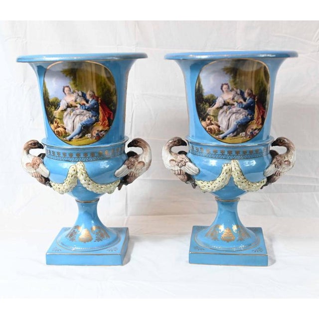 A magnificent pair of French Sèvres-style porcelain urns with a striking turquoise-blue ground Each urn features a finely...