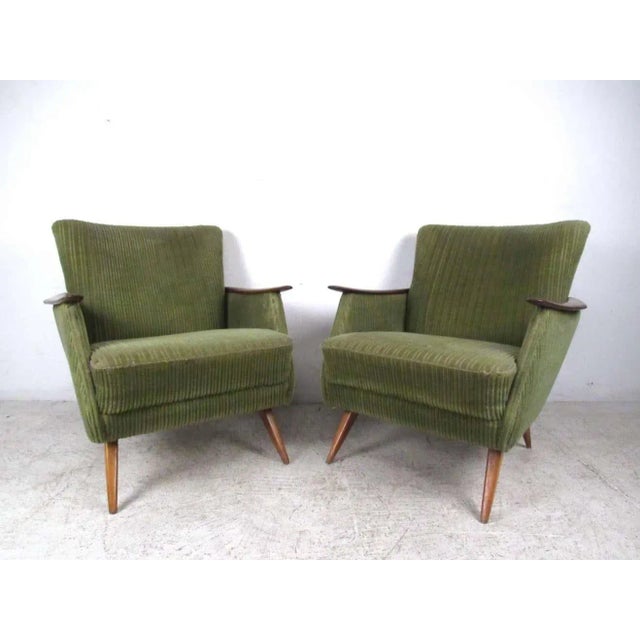 This stunning pair of vintage Danish armchairs features unique tapered legs, sculpted wooden arms, and wraparound wood...