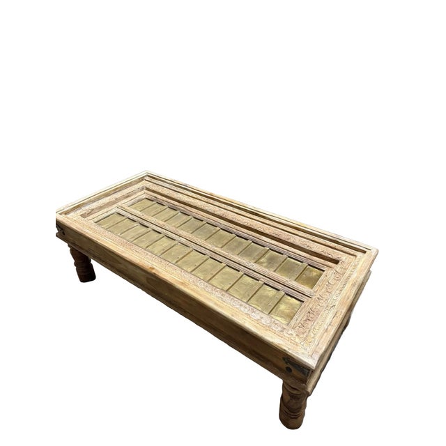 Crafted from an authentic antique Indian door, this distinctive coffee table showcases intricate hand-carved details...