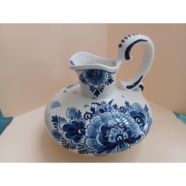 Antique white & blue hand painted Delft pitcher with floral motif. Signed on bottom 350 Delft Holland Handgeschilderd....