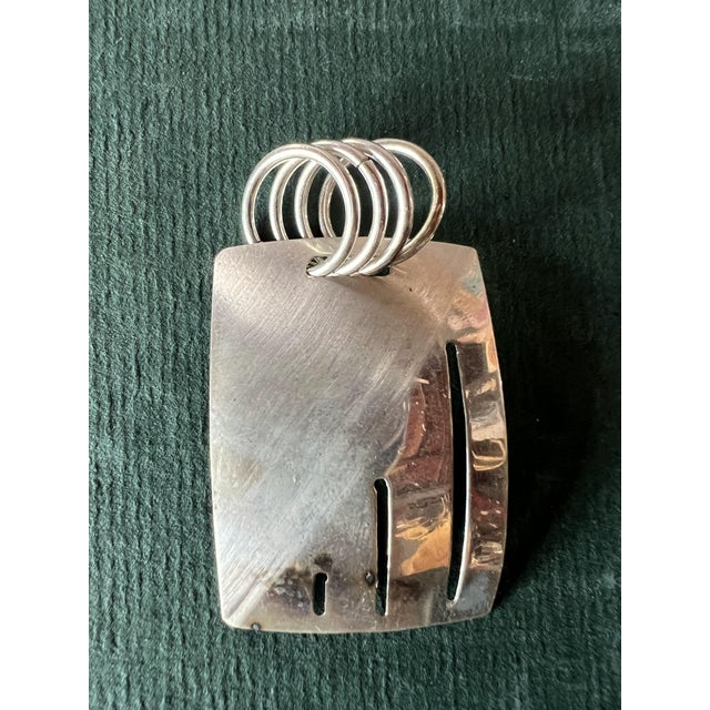 Modernist artisan sterling silver slide pendant. Slightly curved panel with a textured brushed finish. Accentuated cutout...