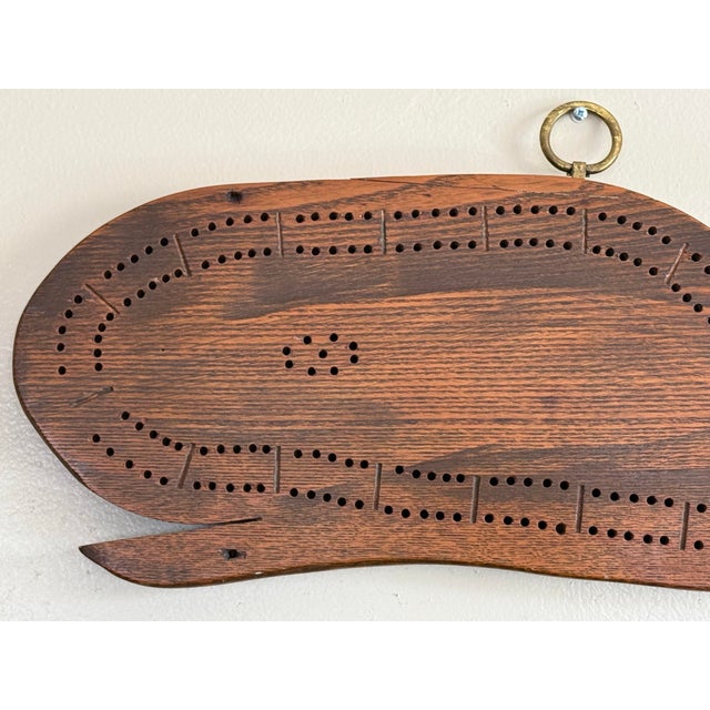 Midcentury Coastal cribbage game board in the shape of a whale. Hand crafted with a brass ring, it is a lovely old coastal...