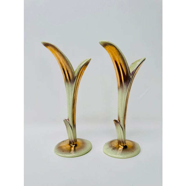 A rare matched pair of 1950s ceramic bud vases attributed to Bauer Pottery. Each features a slender, stylized leaf form...