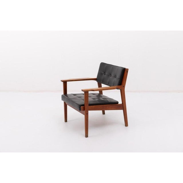 Modern Danish design armchair from 1960s on crafted stained oak frame with the seat and backrest upholstered in black faux...