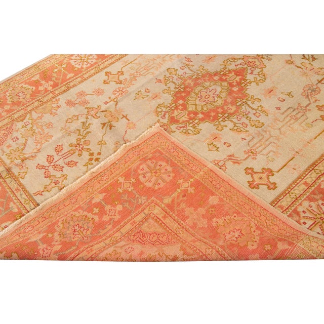 Beautiful Antique Turkish Oushak hand-knotted wool rug with peach and beige field. This Oushak rug has a frame of peach,...