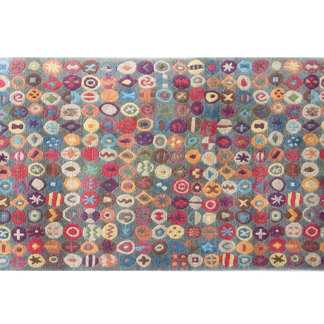 This late 20th-century Tibetan hand-knotted wool runner is a stunning celebration of vibrant color and intricate design....