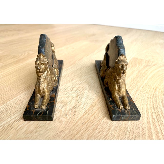 A striking and exceptionally substantial pair of French Art Deco griffin bookends, beautifully crafted with finely...