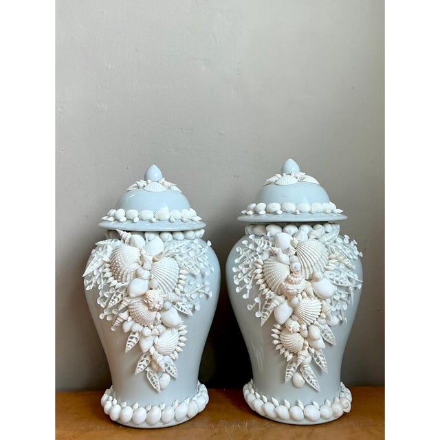 This pair of vintage ceramic lidded urns presents a classic baluster silhouette, with softly shouldered bodies tapering to...