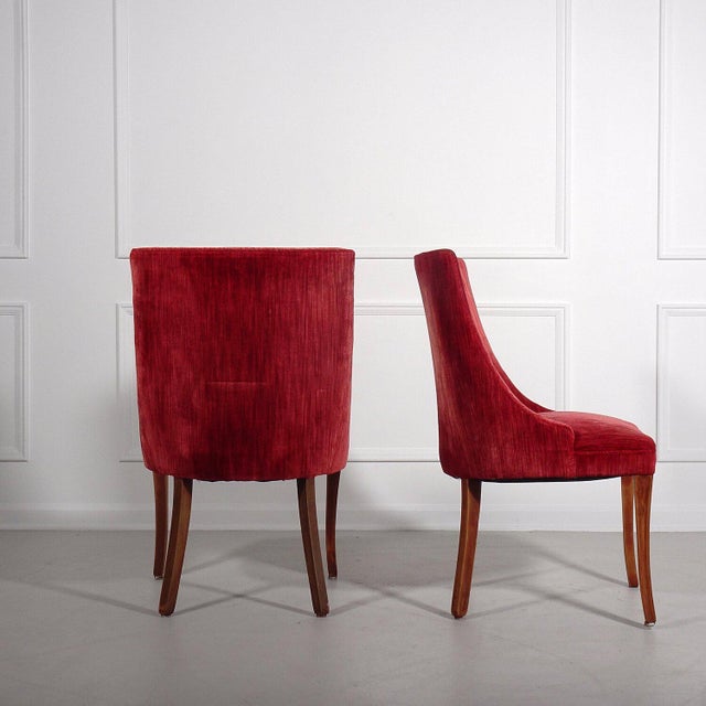 Gorgeous pair of regency side chairs in a raspberry velvet upholstery. Sabre shaped legs with slight distressing....