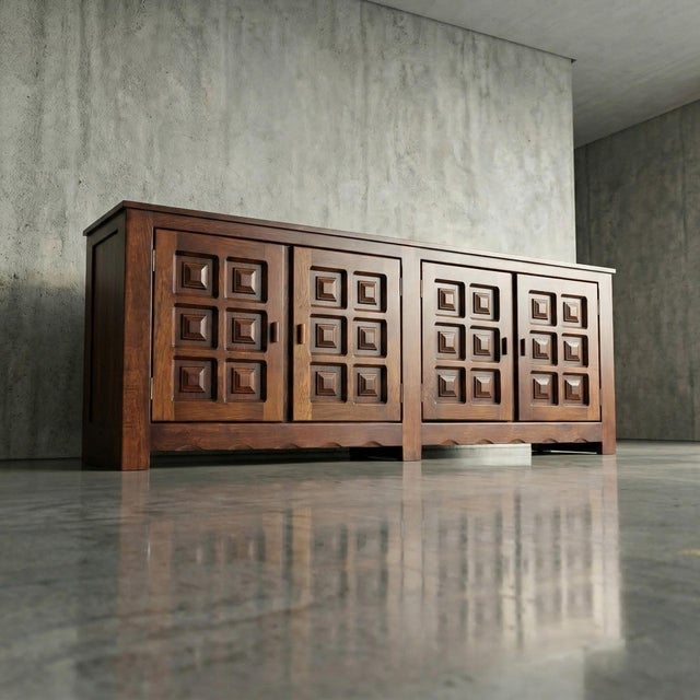 This French solid oak sideboard translates Brutalist geometry into a warm, deeply tactile domestic object. Defined by a...