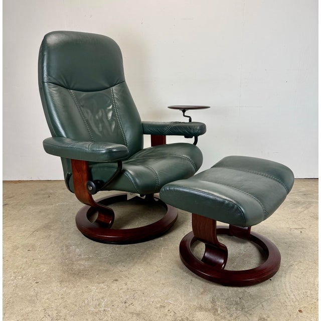 A beautiful, functional, and comfortable vintage dark green leather Stressless recliner and matching ottoman by Ekornes,...