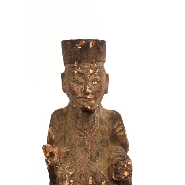 Very old solid wood statue depicts the Taoist Zen Master. He wears typical Tao robe and hat, with two fingers pointing up,...