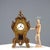 Green and gold wooden pendulum clock, carved with scrolls and painted with a polychrome flower bouquet decoration....