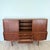 Mid-century teak highboy credenza featuring a sculptural case with softly rounded edges and beautifully figured grain...