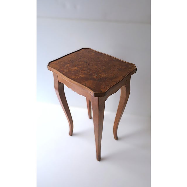 A wood and burl wood end, side, or accent table, in the Rococo style, circa late-20th century. Table is wood with a burl...