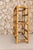 A charming vintage bamboo wine rack featuring a warm honey-toned finish, rounded architectural lines, and beautifully...