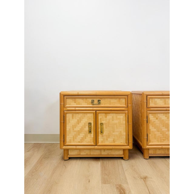 This stunning pair of vintage coastal bamboo parquet nightstands with glass tops are a beautifully crafted and highly...