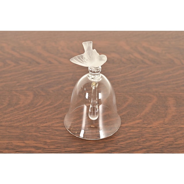 A gorgeous Art Deco or Art Nouveau crystal table bell featuring a detailed, frosted sparrow finial perched atop a clear...