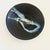 A large circular vintage studio pottery bowl. Matte black glaze with a glossy blue abstract design in the center. Ribbed...