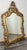 A richly detailed Vintage French mirror featuring an ornate gold frame with intricate scrolling and carved decorative...