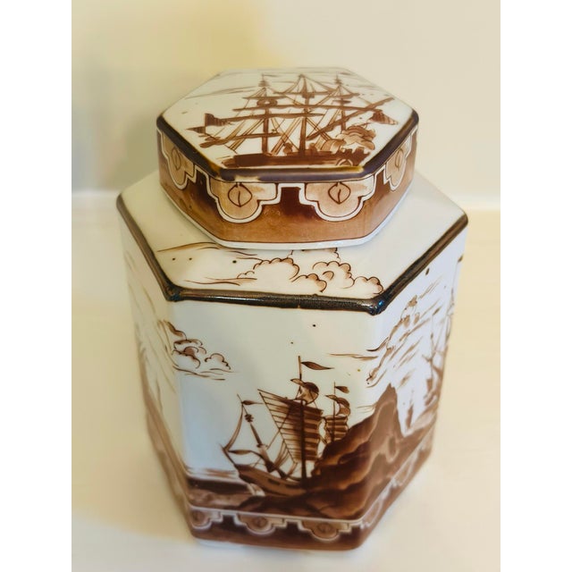 Vintage porcelain tea caddy featuring an elegant square form with a fitted lid, beautifully decorated in rich sepia...