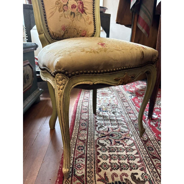 Painted French side chair with a serpentine carved crest and apron picked out in gilt, cabriole legs, and a cartouche-...