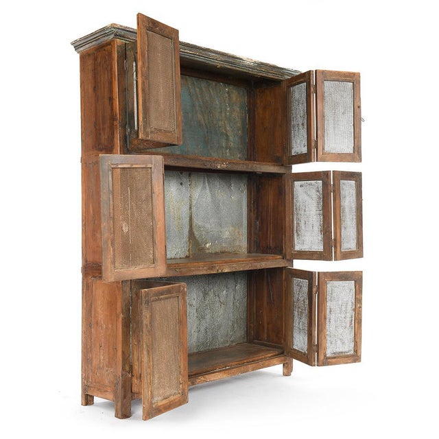 Large antique wooden wardrobe with a wire mesh front, typical of utilitarian storage furniture from the late 19th/early...