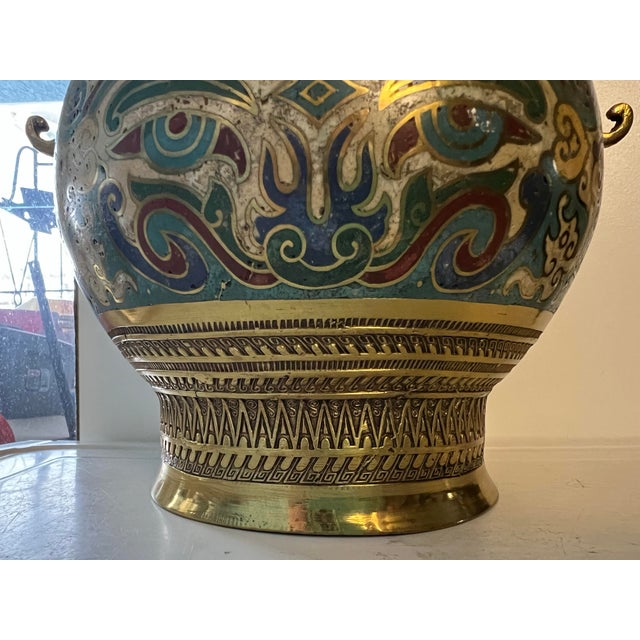 This is a vintage Japanese champlevé cloisonné brass vase with decorative handles. It features a bulbous body with...