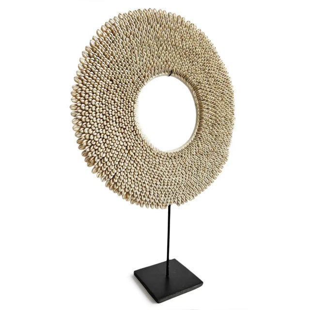 Beautiful hand crafted cowry shell ring displayed on black iron stand. Intricate embroidered natural white cowry shells...