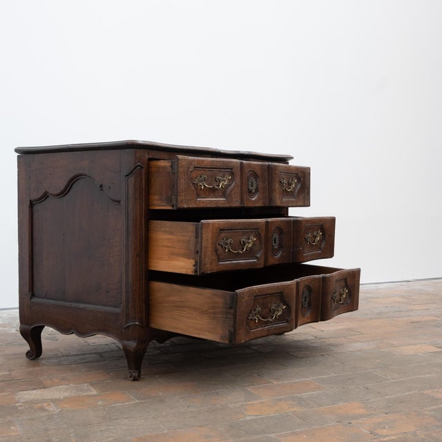 An elegant Louis XV commode with three large drawers in the front. Beautifully sculpted front and paneled sides rest on...
